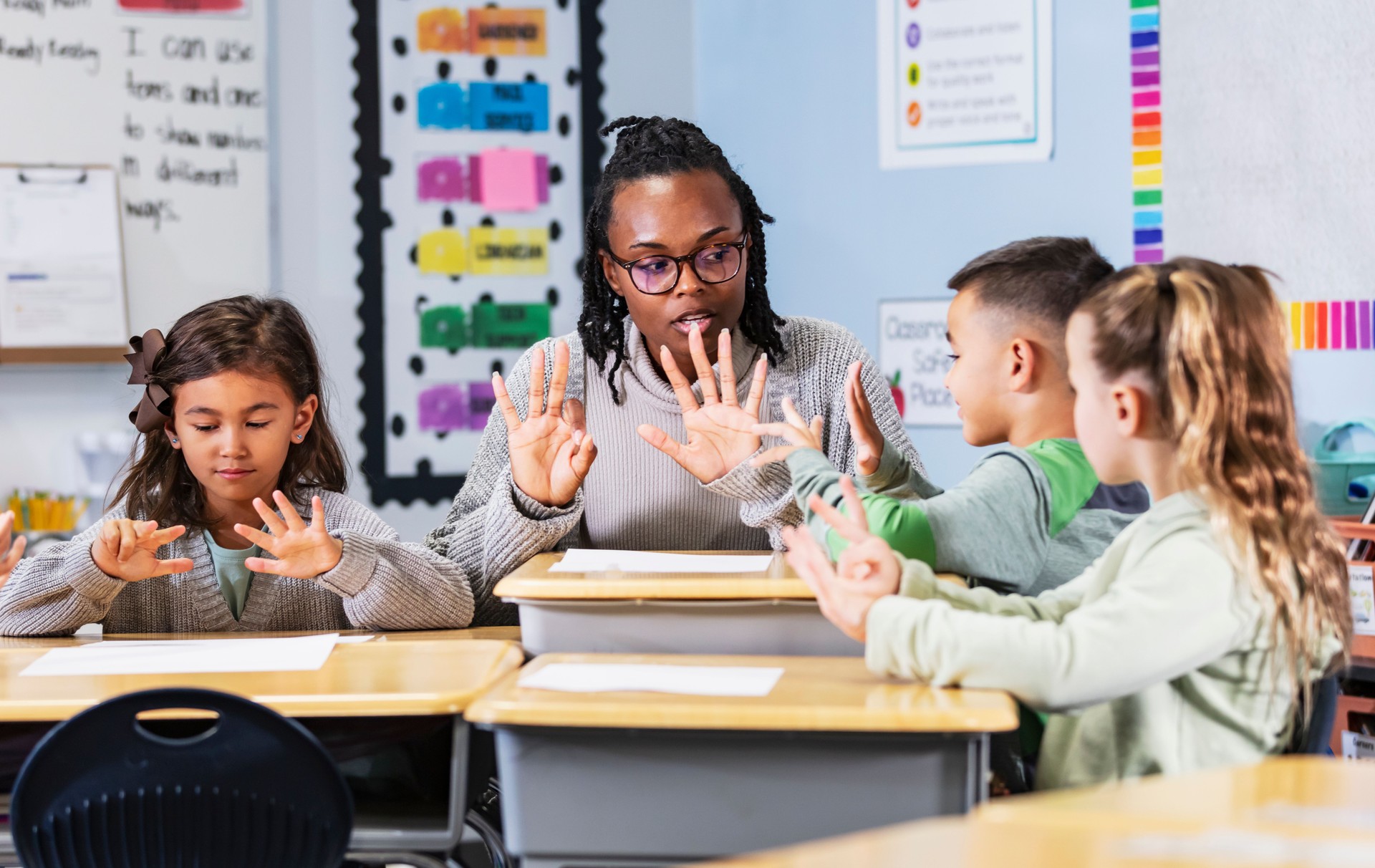 Elementary school teacher teaching four students in class
