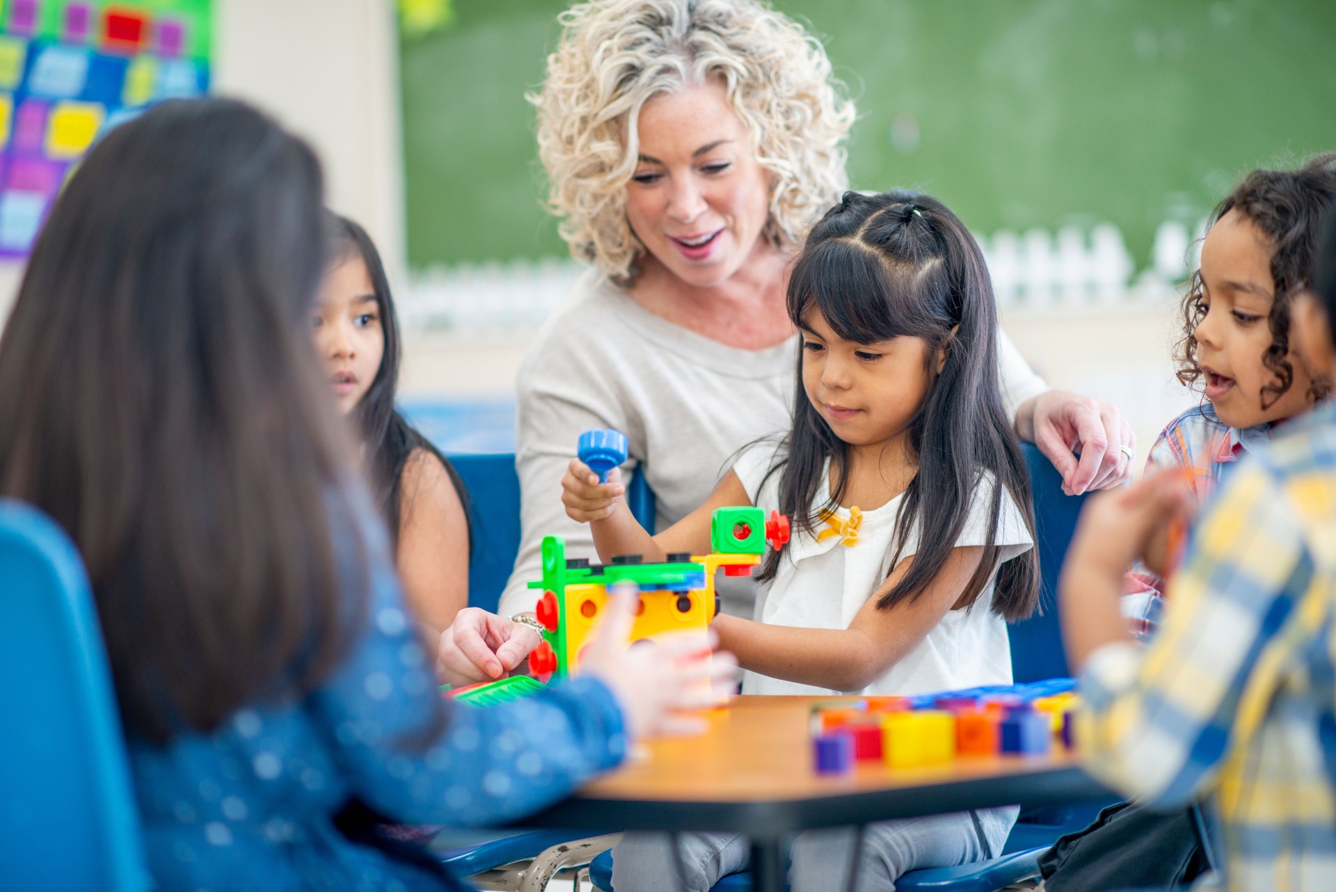 Kindergarten Teacher Helping Students